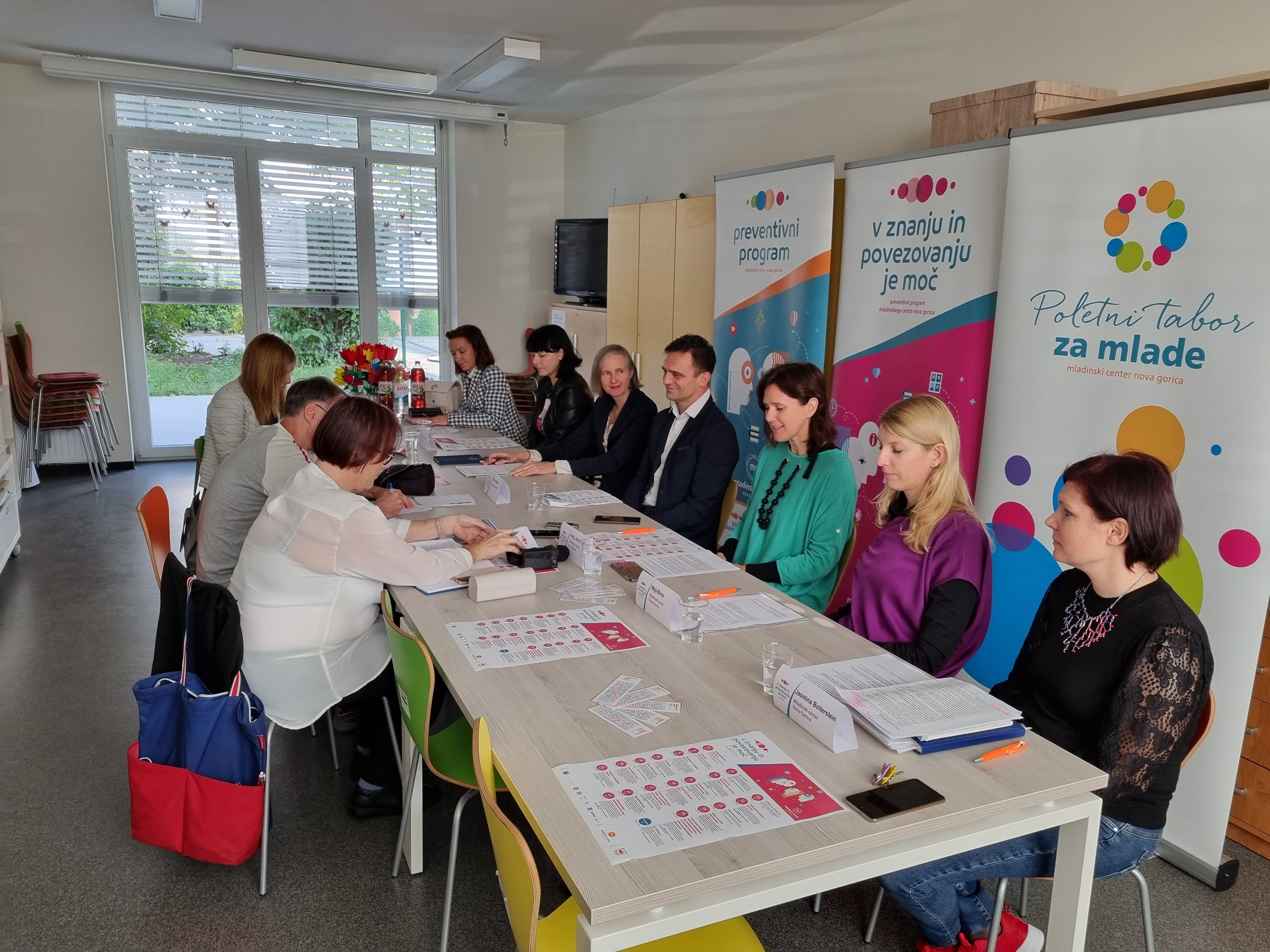 Sodelujoči na konferenci zbrani za mizo.