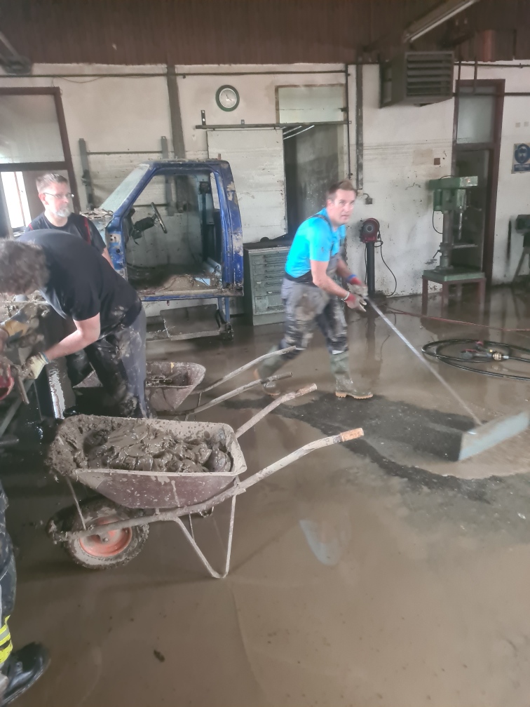 Fantje, med njimi župan Samo Turel, čistijo blatne prostore.