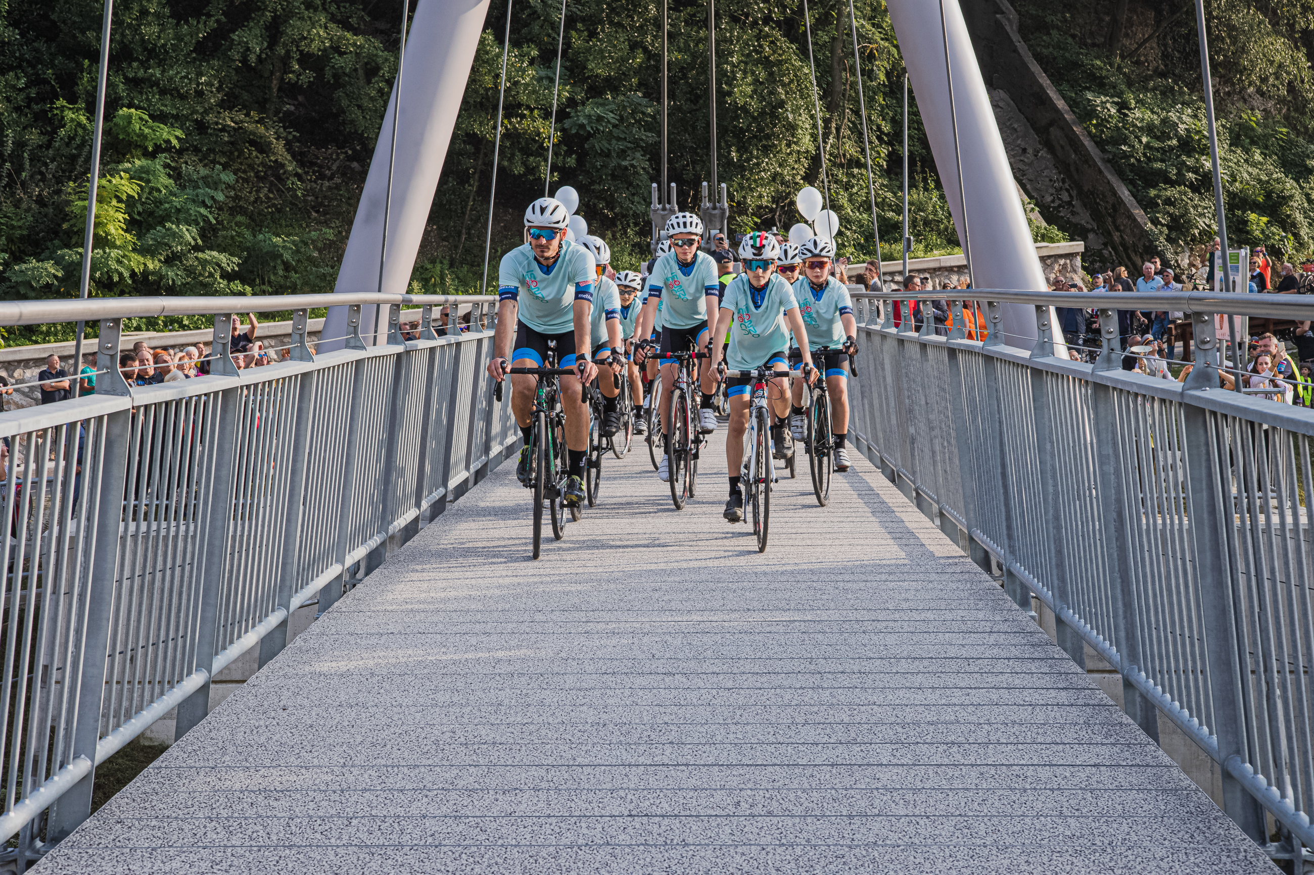 Mladi kolesarji Kolesarskega kluba Meblo jogi se vozijo čez brv.