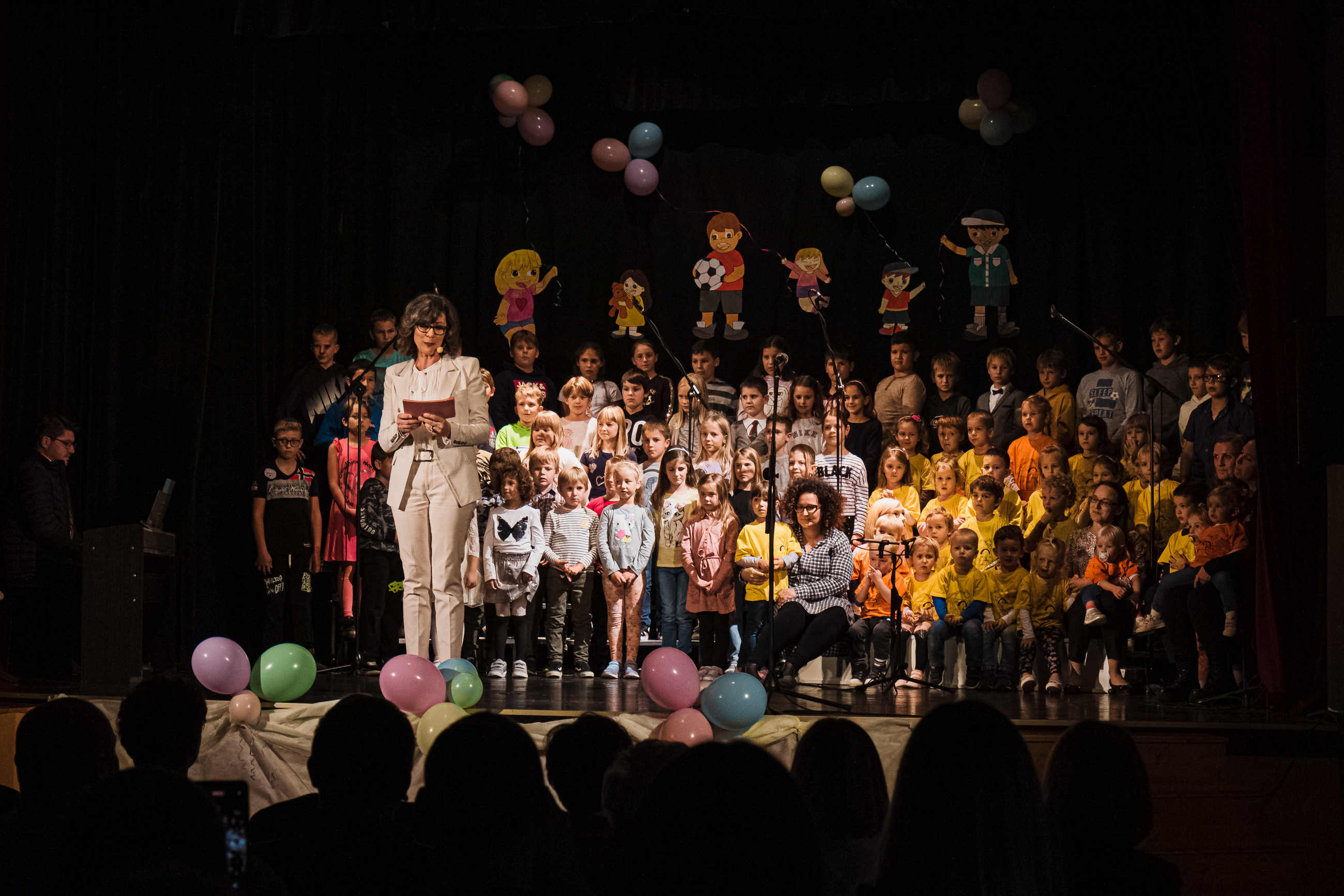 Damjana Golavšek in otroci na odru med kulturnim programom.