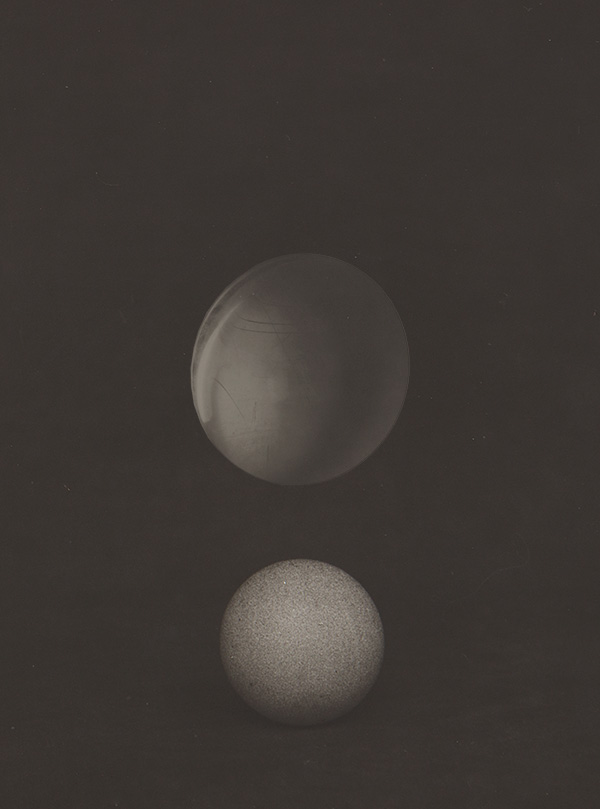 Črno-bela fotografija, na kateri sta dve svetlejši krogli